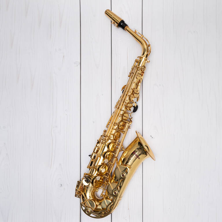 Ein Alt-Saxophon liegt auf einem hellen Holzuntergrund.